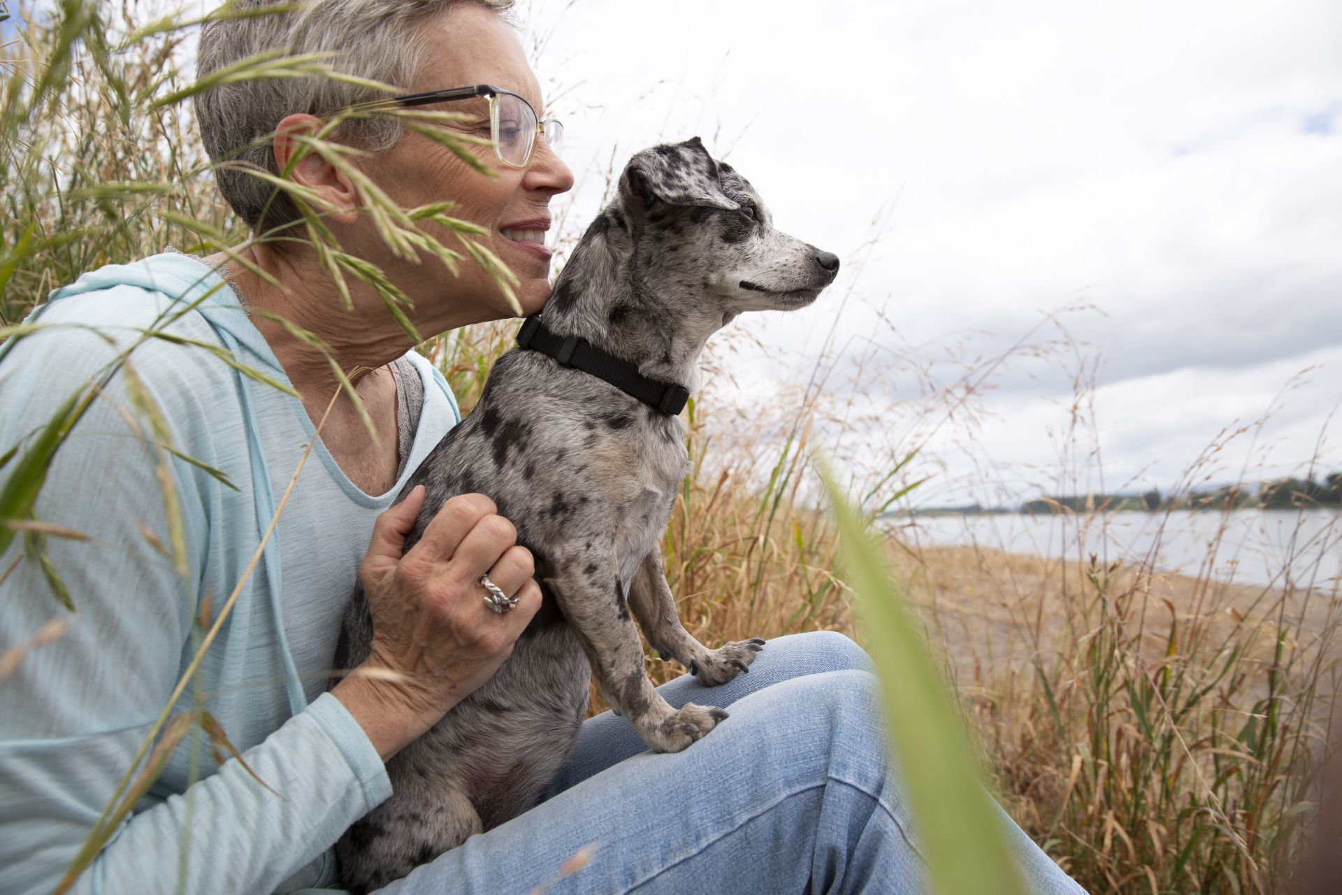 Woman with small and speckled dog gazing at the river view