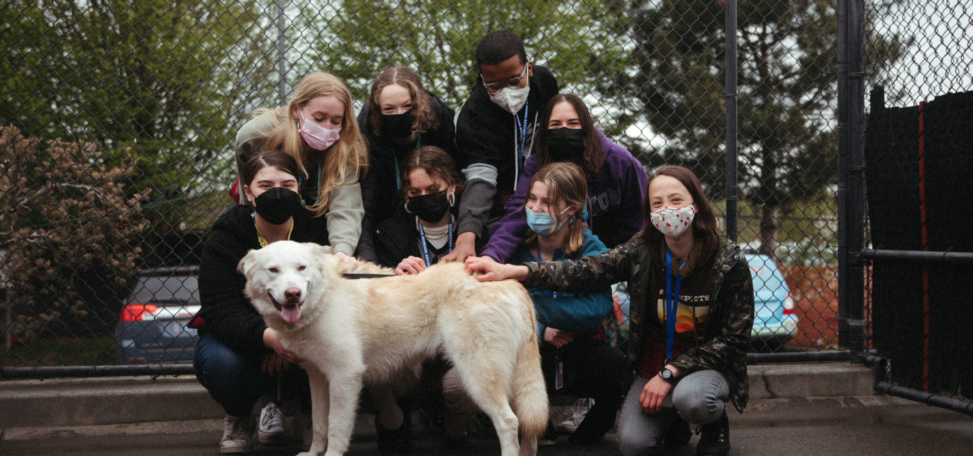 Youth Volunteers in outdoor run with dog